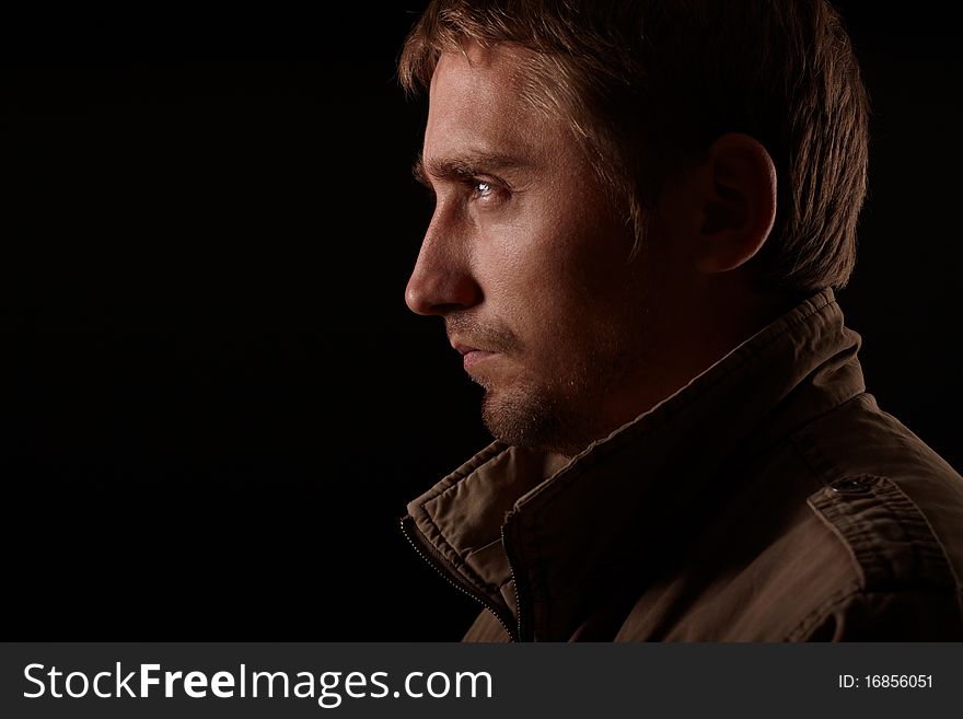 The portrait of young man on black background