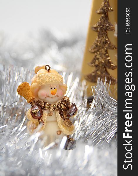 Christmas background with cheerful toy snowman and silver Christmas tinsel. Christmas background with cheerful toy snowman and silver Christmas tinsel