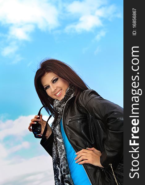 Young smiling pretty girl on blue sky background. Young smiling pretty girl on blue sky background