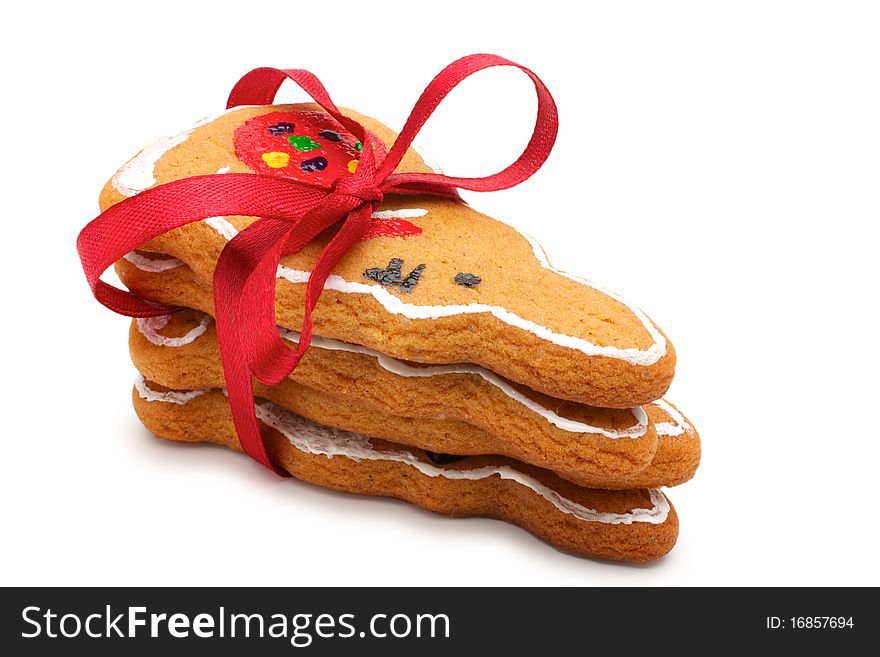 A stack of Christmas cookies in the amount of three pieces. Cookies in the shape of hares. Pile tied a red ribbon. Painted cookies manually. Isolated on white background. A stack of Christmas cookies in the amount of three pieces. Cookies in the shape of hares. Pile tied a red ribbon. Painted cookies manually. Isolated on white background.