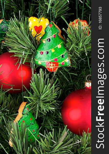 A fragment of a Christmas tree. Christmas tree decorated with Christmas cookies and balloons. Cookies are hand-painted. Spruce artificial. The balls are red. Cookies of different shapes. A fragment of a Christmas tree. Christmas tree decorated with Christmas cookies and balloons. Cookies are hand-painted. Spruce artificial. The balls are red. Cookies of different shapes.