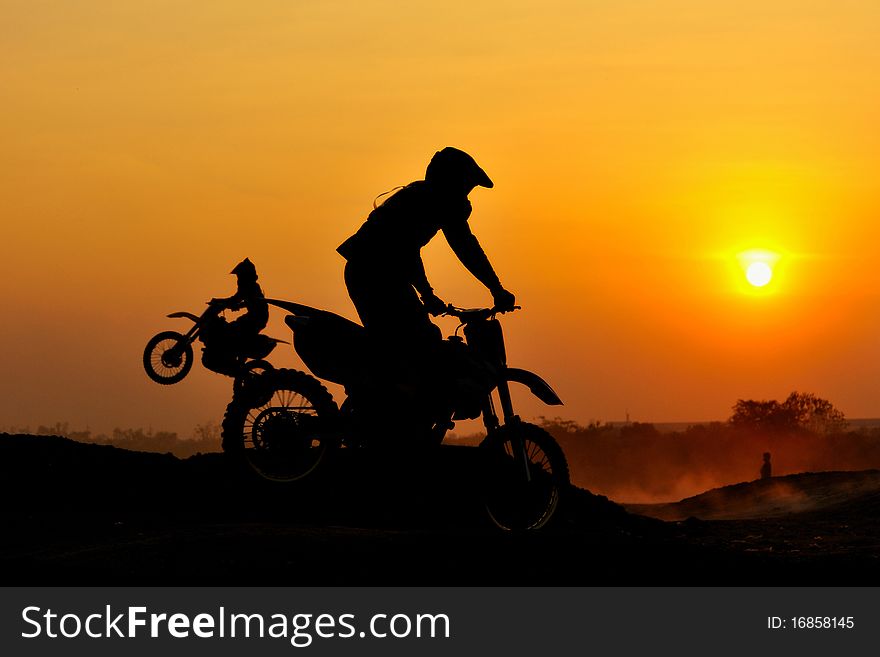 Motocross rider action in silhouette.