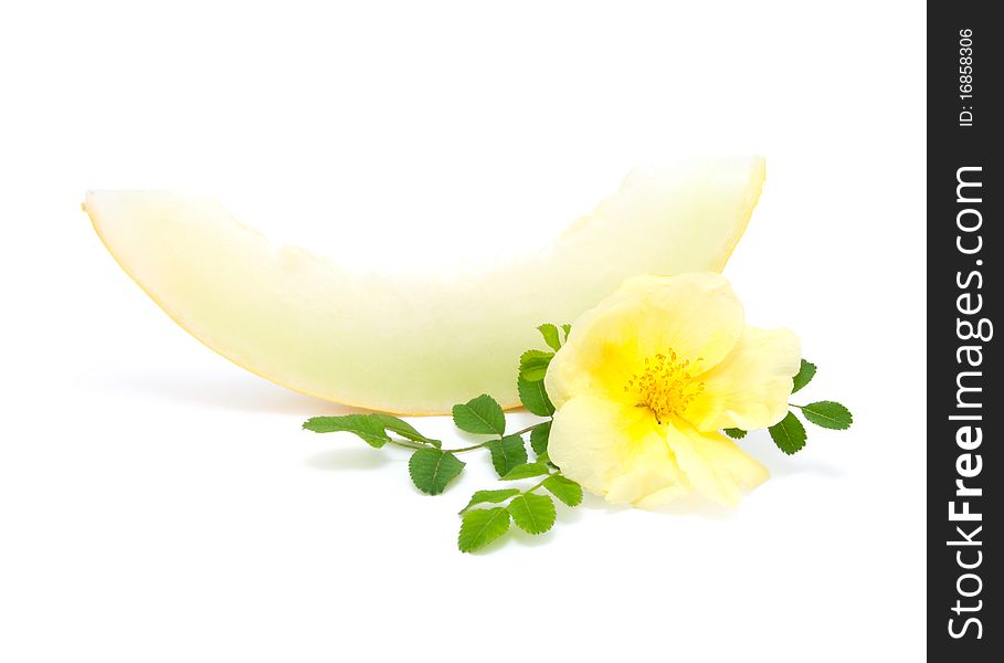 Slice of yellow melon with flower, on a white background