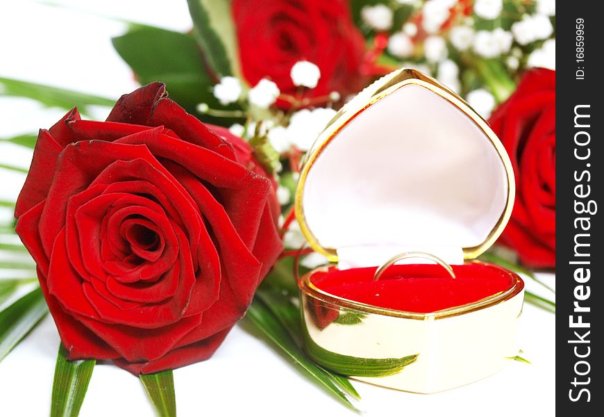 Red rose and wedding ring on a white background