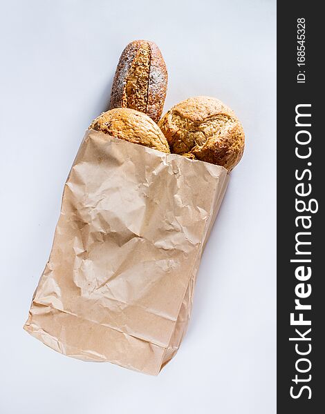 Whole grain bread with seeds in ecology paper bag on light gray background. Top view flat lay. Healthy food. Save ecology concept. Zero waste recycling