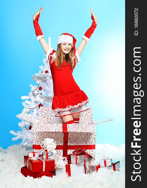 Beautiful young woman in Santa Claus clothes over Christmas background. Beautiful young woman in Santa Claus clothes over Christmas background.