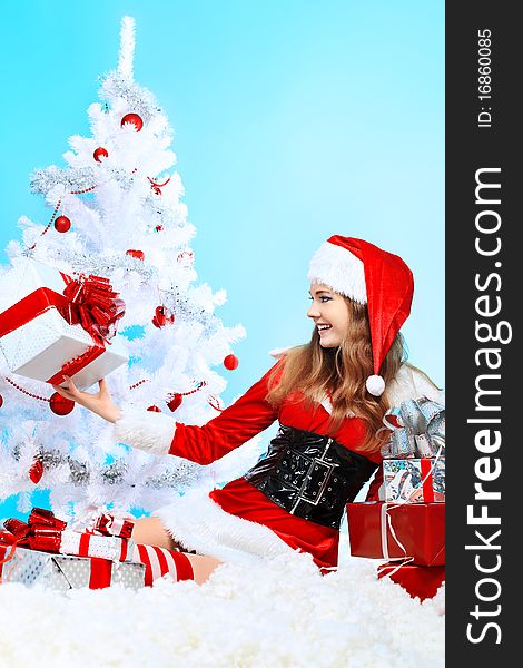 Beautiful young woman in Santa Claus clothes over Christmas background. Beautiful young woman in Santa Claus clothes over Christmas background.