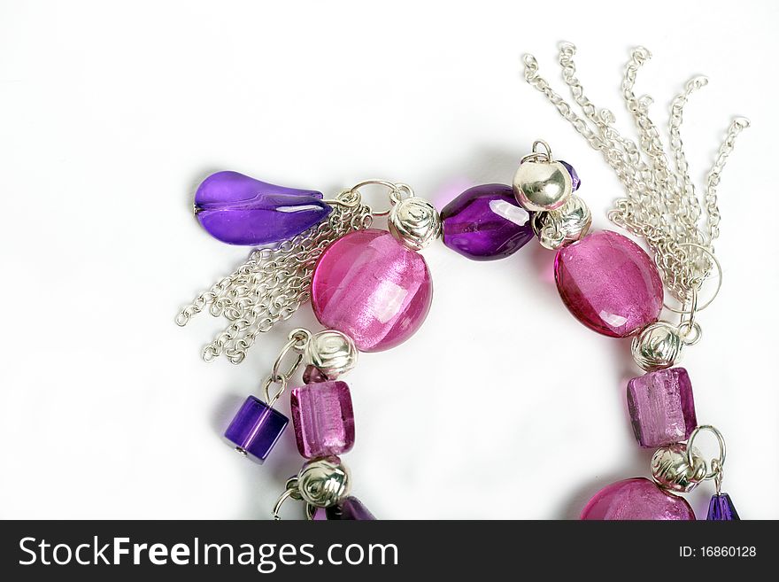 A bracelet with pink and purple beads on a white background. A bracelet with pink and purple beads on a white background