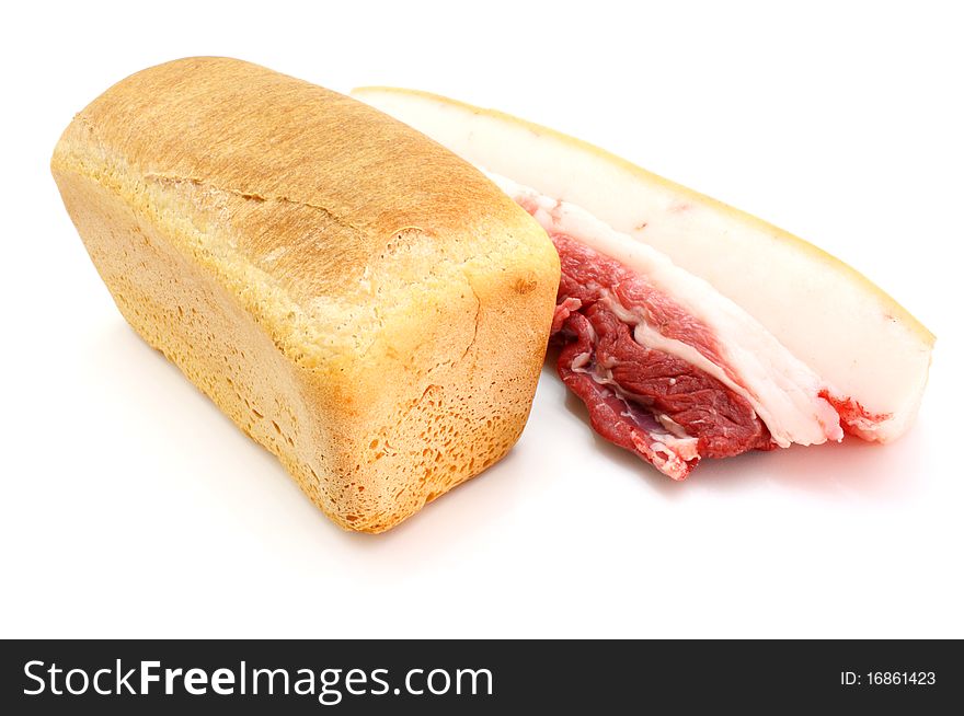 Roll of fresh bread and the big piece of fat with meat on a white background