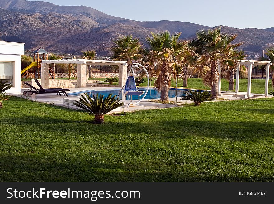 Swimming pool, sunbeds and palms at luxury villa, Crete, Greece. Swimming pool, sunbeds and palms at luxury villa, Crete, Greece