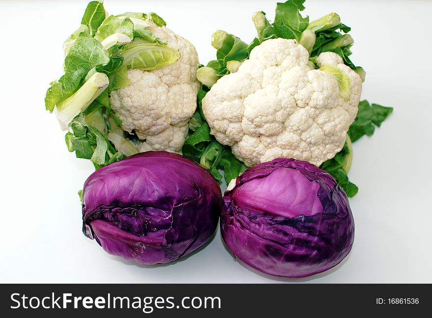Freshly cut red and cauliflower cabbage isolated on white . Freshly cut red and cauliflower cabbage isolated on white .