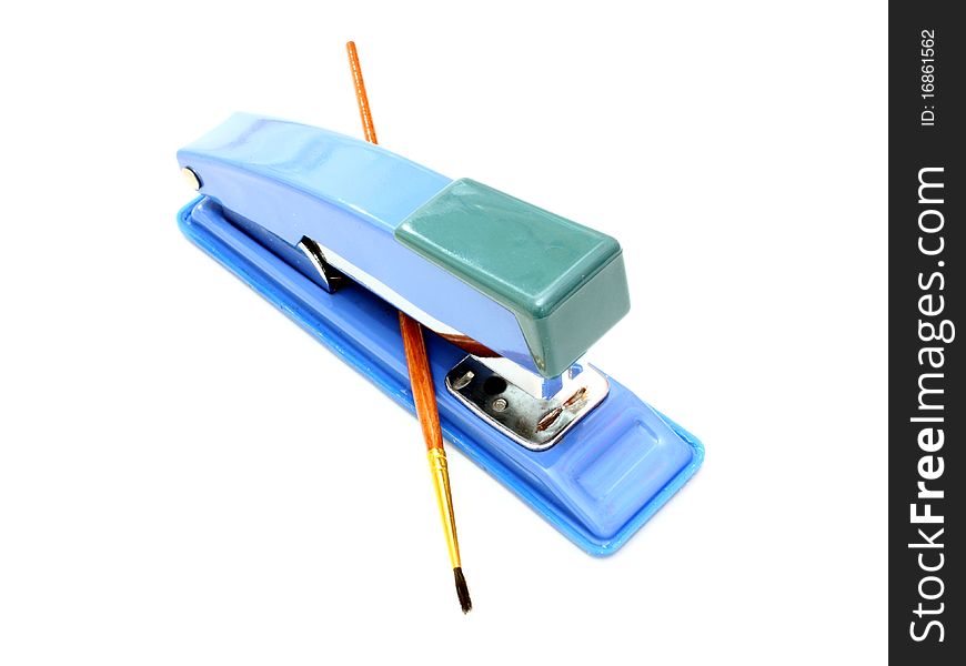 Stapler of dark blue color and brush for paints on a white background. Stapler of dark blue color and brush for paints on a white background