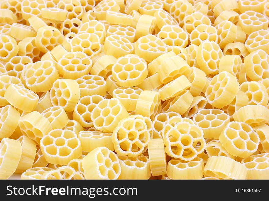 Yellow pasta in the form of wheels on a white background a structure