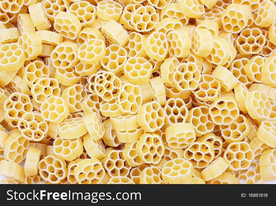 Yellow pasta in the form of wheels on a white background a structure
