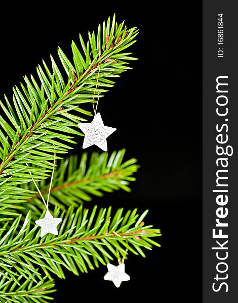 Fir branch with hanging Christmas decorations on a black background. Fir branch with hanging Christmas decorations on a black background.