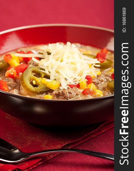 A turkey based white chili topped with cheese and peppers