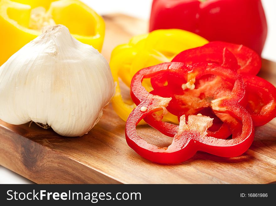 Fresh red and yellow peppers sliced into rings with garlic