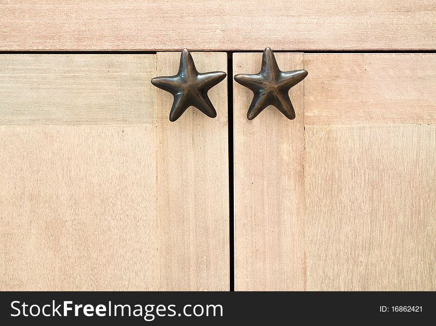 Star shape cabinet handles on wooden cabinet