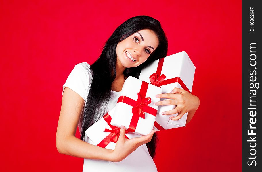 Pretty young brunette woman dressed in red dress with many presents. Pretty young brunette woman dressed in red dress with many presents