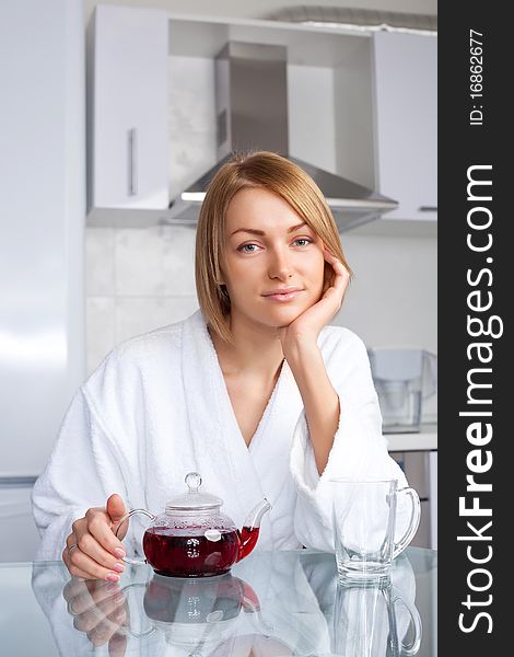 Beautiful young woman drinking tea at home in the morning