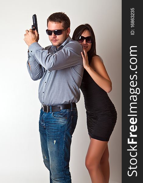 Man with a gun and the woman in sun glasses. Man with a gun and the woman in sun glasses