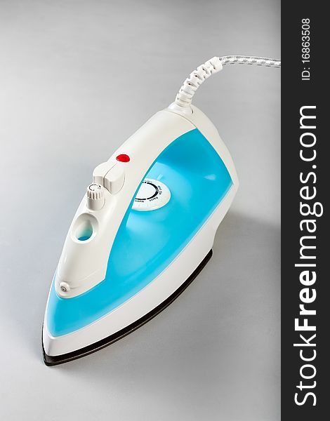 White blue electric steam iron on a white background