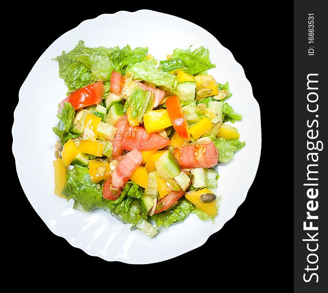 Salad with tomato, pepper, pumpkin seeds on the white  plate isolated
