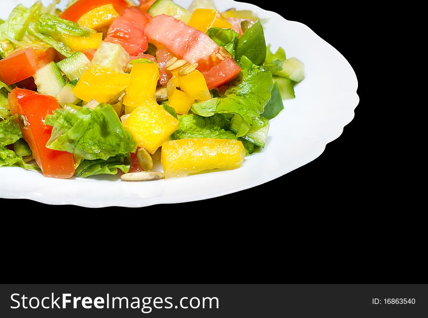 Salad with tomato, pepper, pumpkin seeds on the white plate isolated