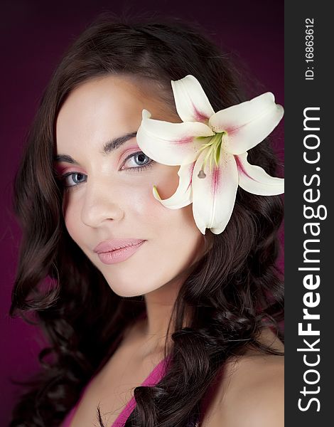 Beautiful girl with lily on the red background