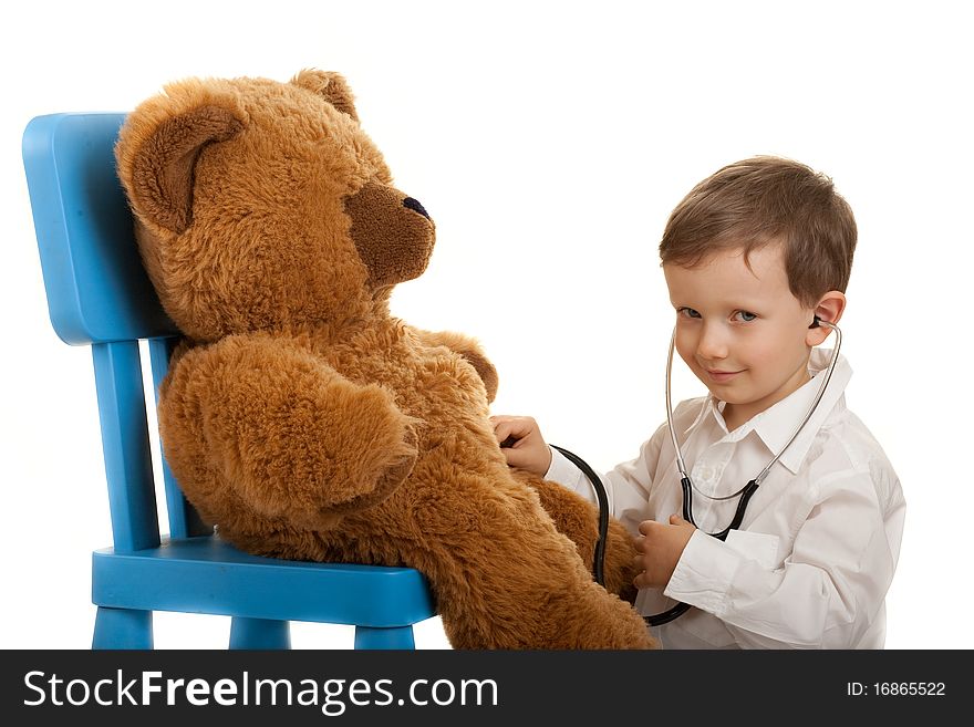 Child playing in doctor with stethoscope examination teddybear. Child playing in doctor with stethoscope examination teddybear.