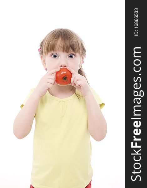 The portrait of a cute little girl holding a red tomato in her hands