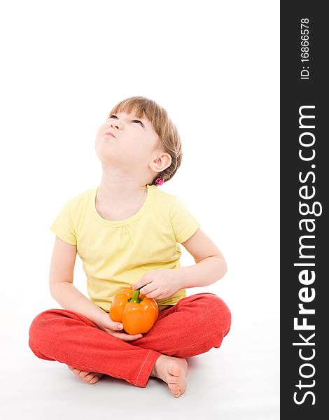 The portrait of a cute little girl holding a fresh pepper