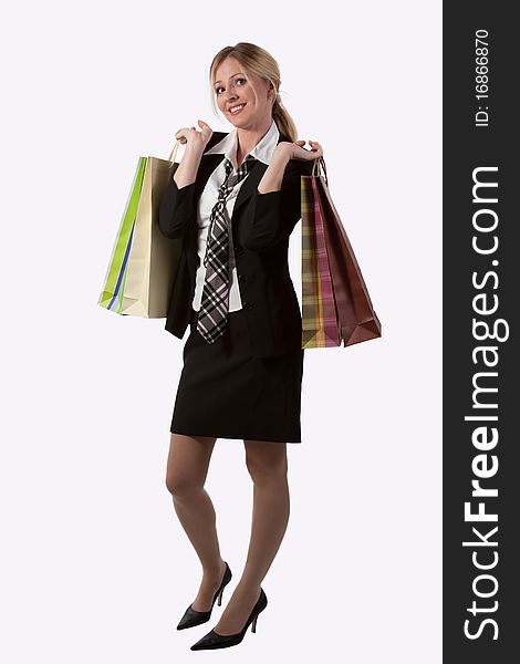 Full body of an attractive blond woman in business suit holding shopping bags standing on white. Full body of an attractive blond woman in business suit holding shopping bags standing on white