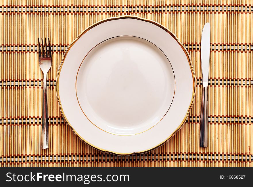Empty plate with fork knife on table. Empty plate with fork knife on table