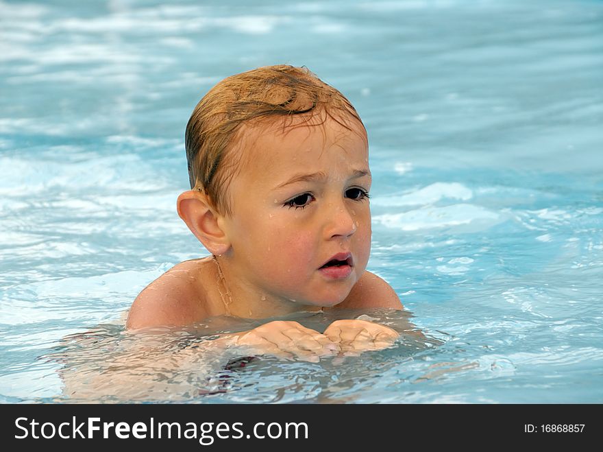 Blond boy at his first swimming attempts.