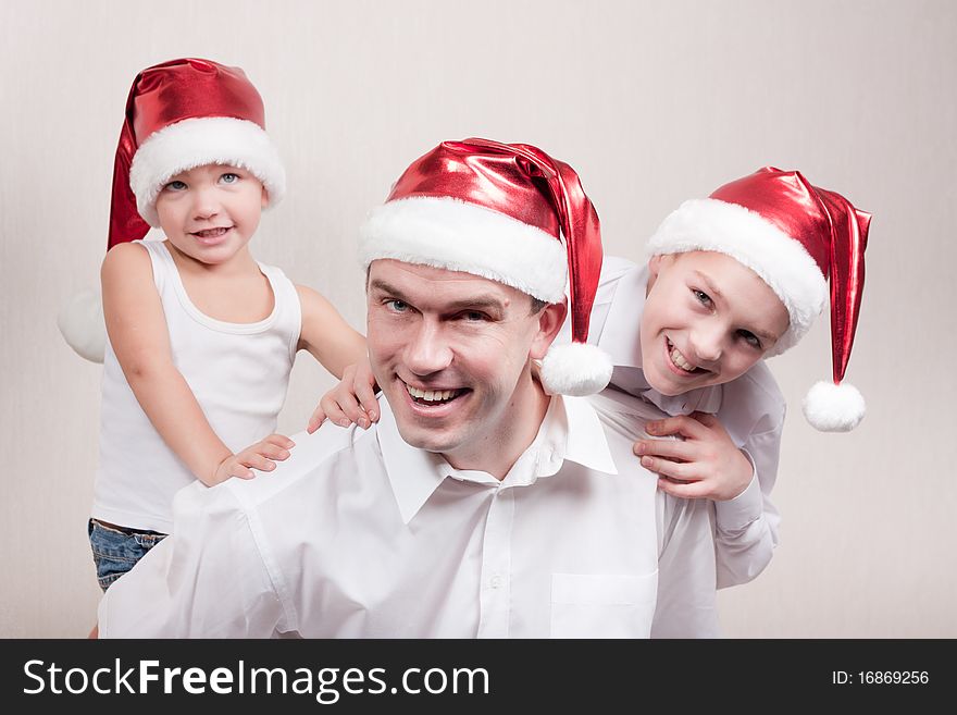 Happy and merry father and two sons in santa hat. Happy and merry father and two sons in santa hat