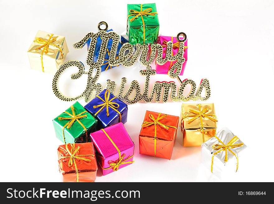 Colorful wrapped gift with a board written merry christmas. Colorful wrapped gift with a board written merry christmas