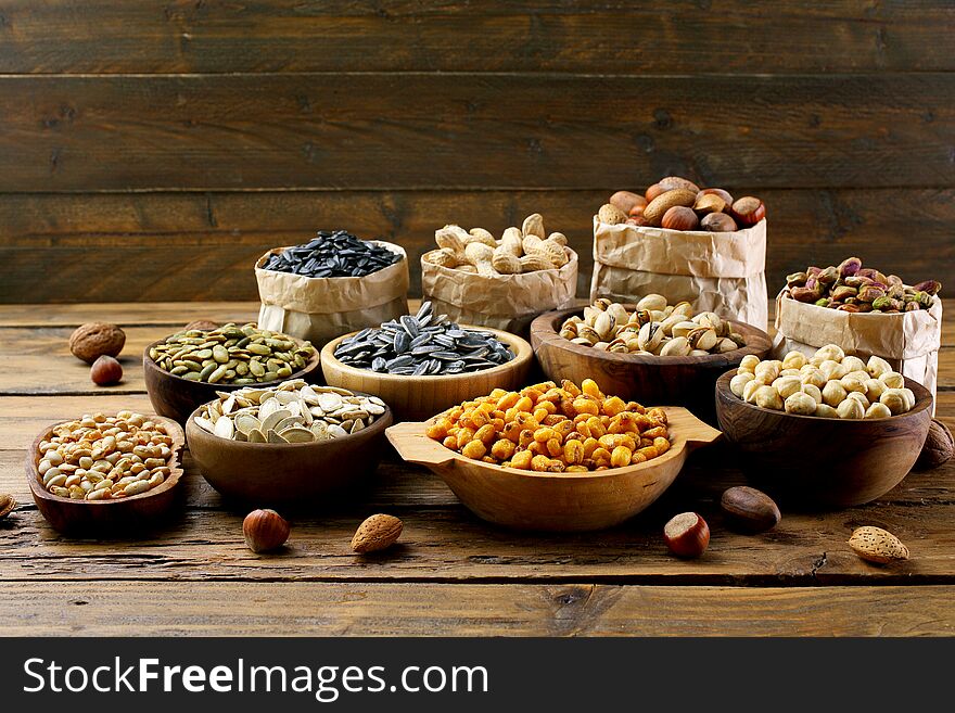Salted seeds and nuts on wooden table background