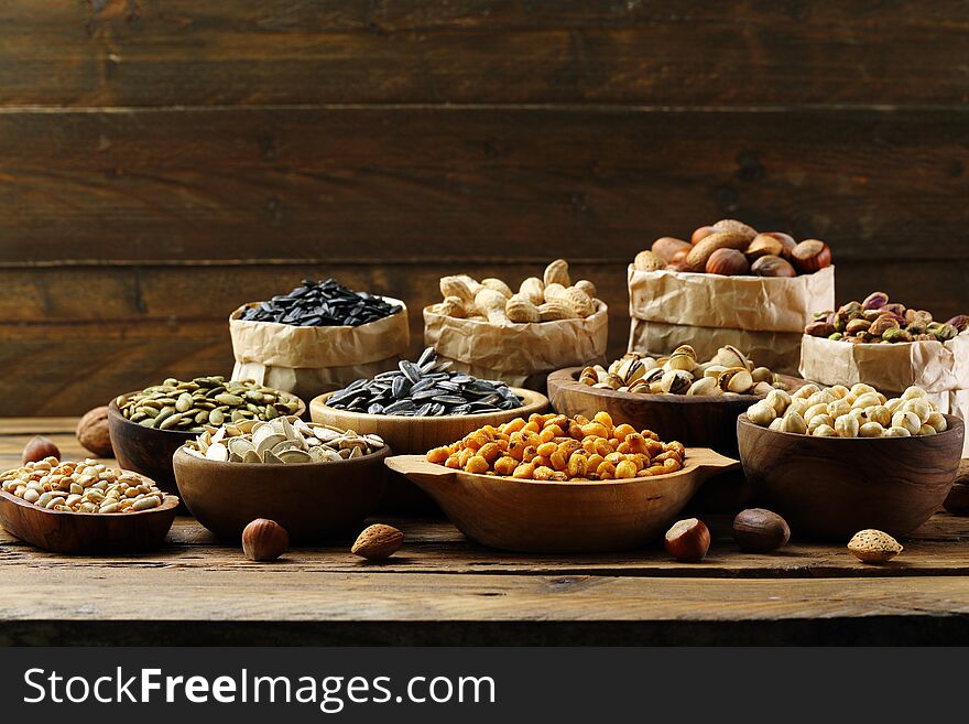 Salted seeds and nuts on wooden table background