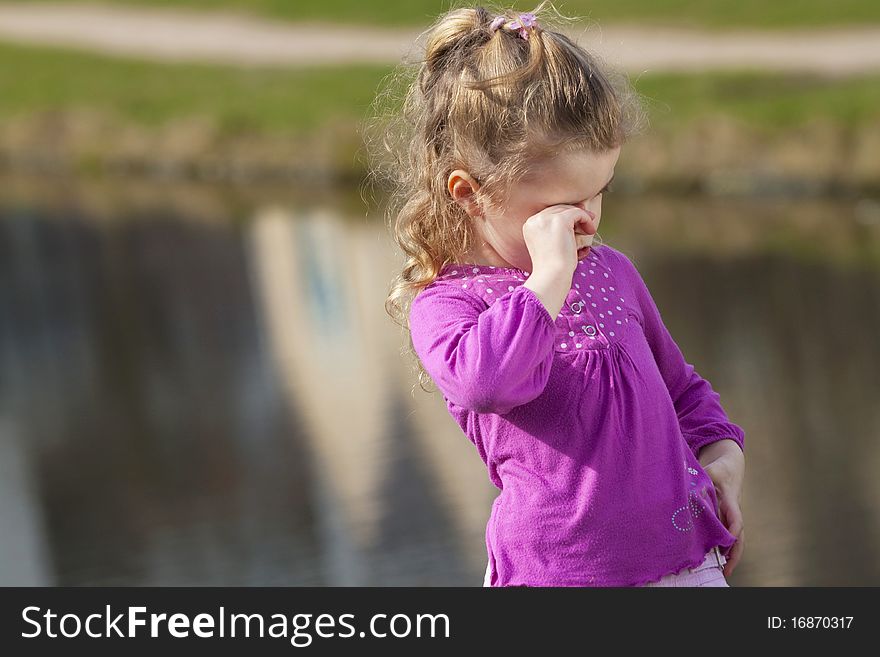Crying girl ashore river.