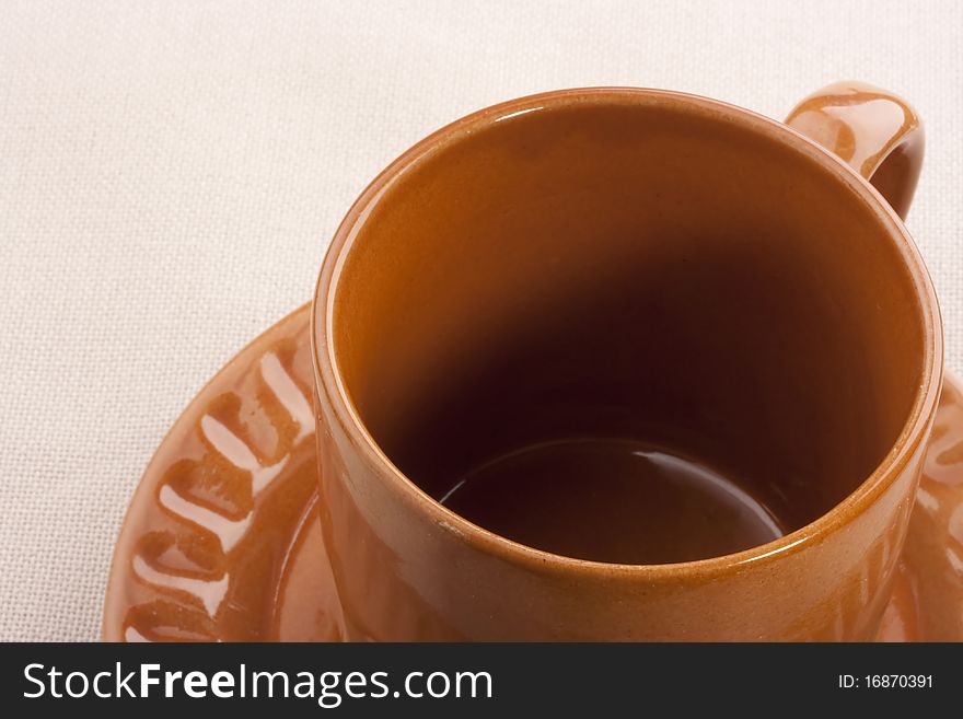Empty ceramic cup with a saucer on a white background.