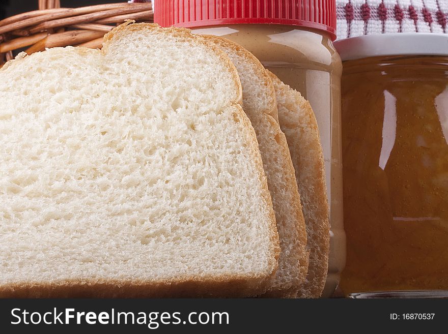 Peanut butter in the plastic container and components for a sweet sandwich.