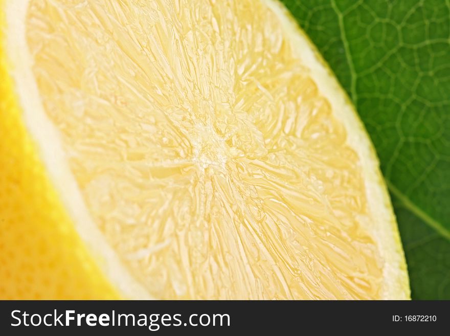 A fresh cutted lemon with a green leaf in backgrond. A fresh cutted lemon with a green leaf in backgrond.