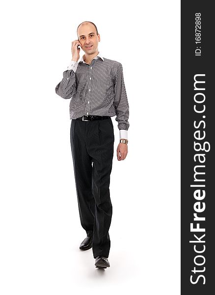 Portrait of happy businessman talking on mobile phone while walking - White background