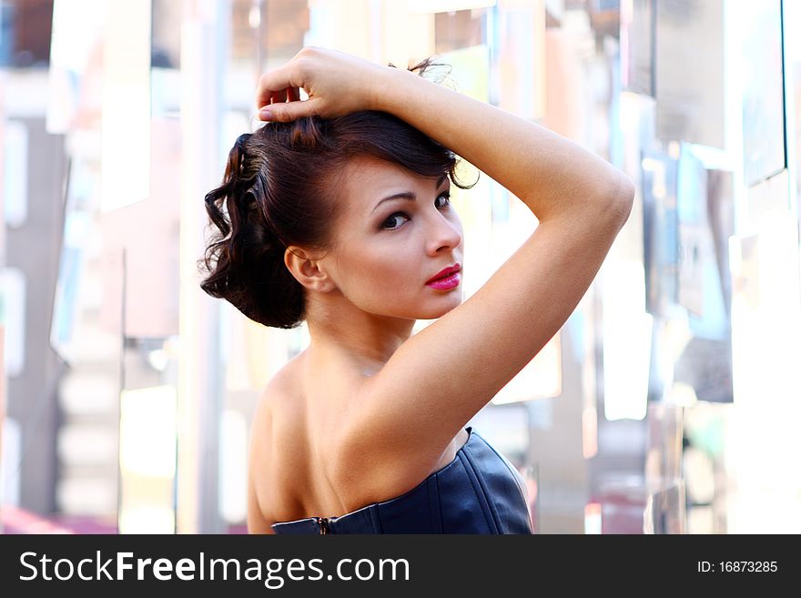 Young and attractive lady in black and pink dress at abstract glass background