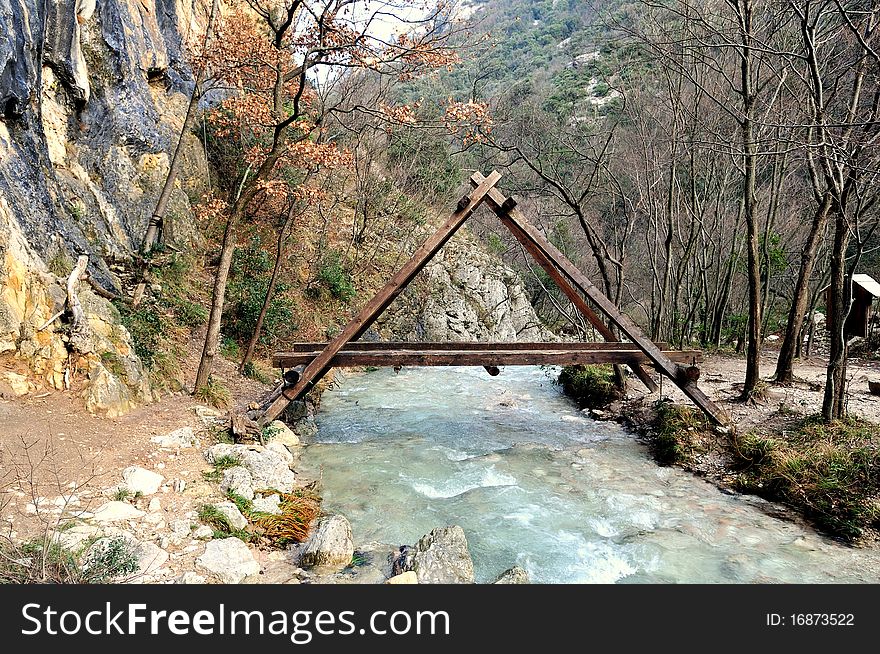 "A" shaped wooden bridge across a mountain creek. "A" shaped wooden bridge across a mountain creek