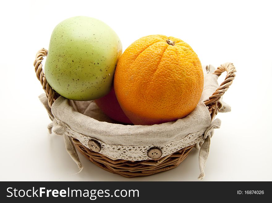 Oranges and apple in the basket with material coating