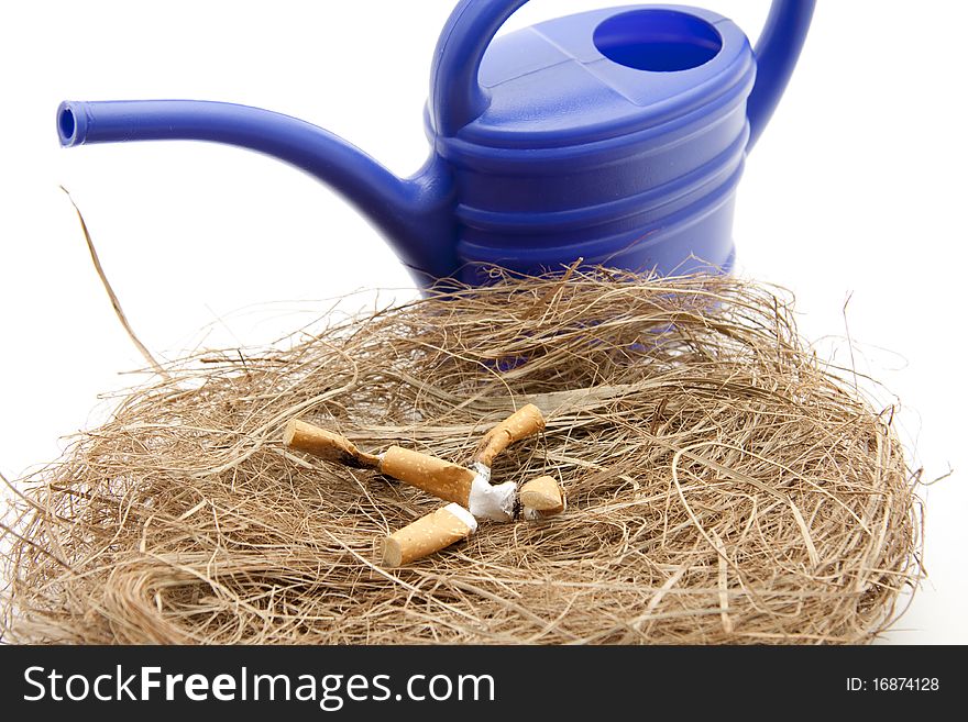 Cigarette with watering can in the dried grass