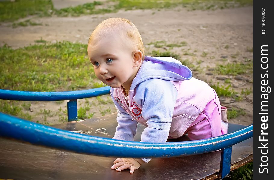 Beautiful Baby Girl Climbing A Slide In Playground