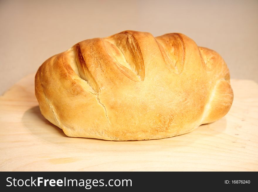 One fresh whole wheat bread on a cutting board. One fresh whole wheat bread on a cutting board